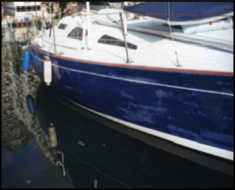 Gelcoat of dark blue boat worn though by repeated abrasive compounding